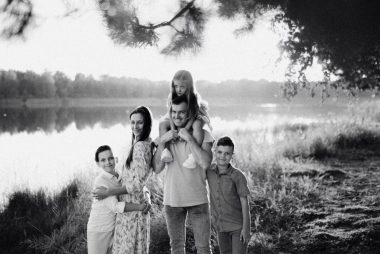 A joyful family enjoying time by the lake in a serene setting.